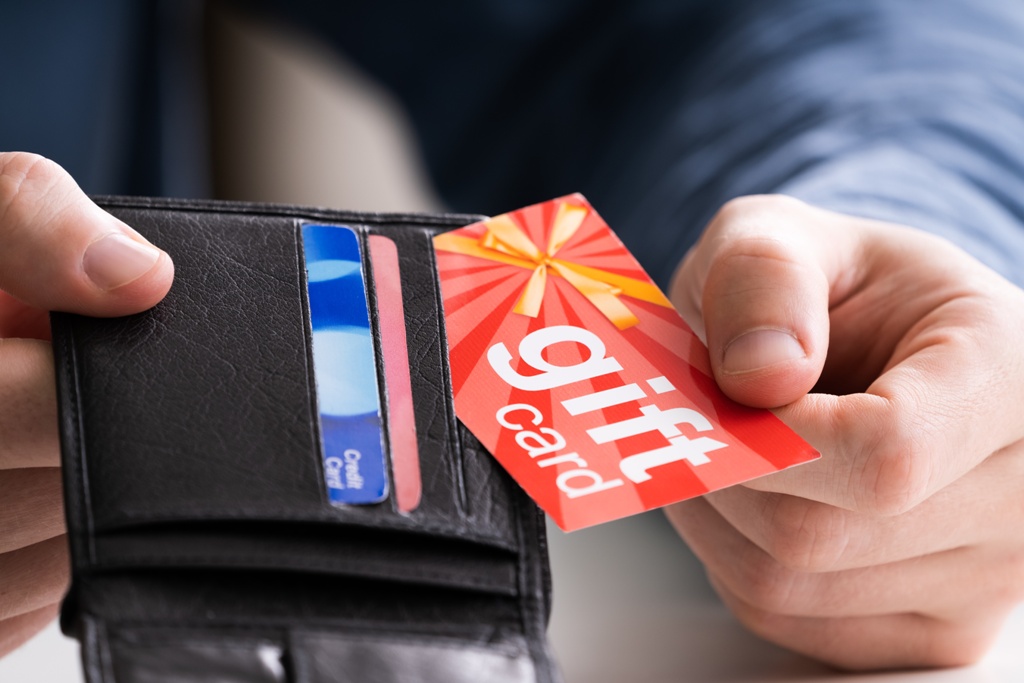 Close-up Of A Human Hand Removing Red Gift Card From Wallet | Walnut Creek Aesthetics in Walnut Creek, CA